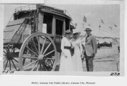 Women and Man Standing By Stagecoach