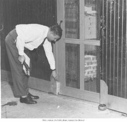 Man Examining Screen Door