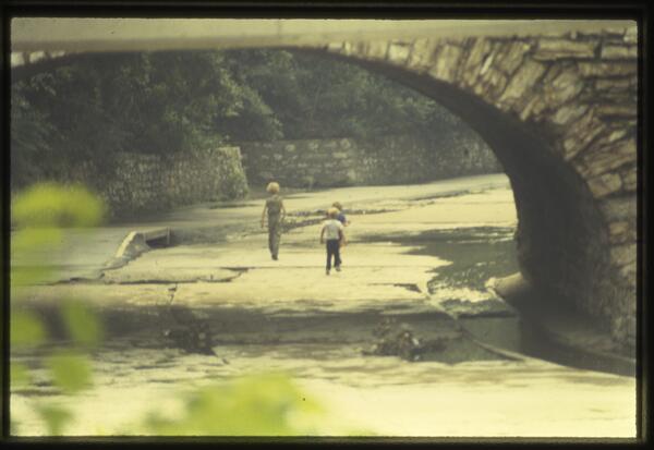 Children walk along the concrete bed of Brush Creek in the 1980s