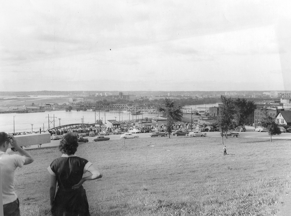 A crowd in West Terrace Park views damage from the 1951 flood, including three barges that crashed into the Hannibal Bridge.