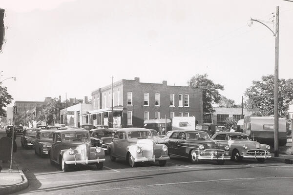 Black and white photo of automobiles waiting at a stoplight