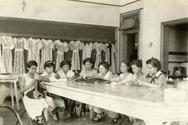 Group of women at a table sewing