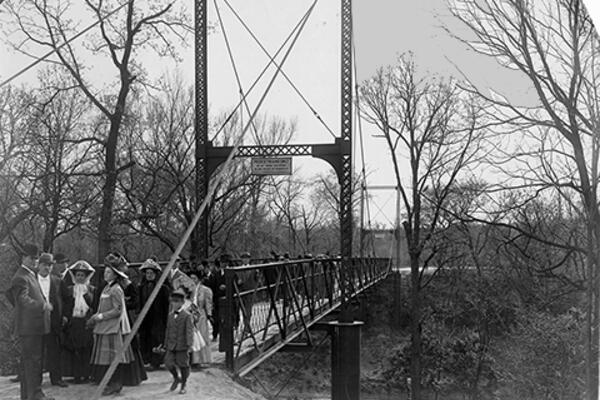 Black and white photo of a small suspension bridge