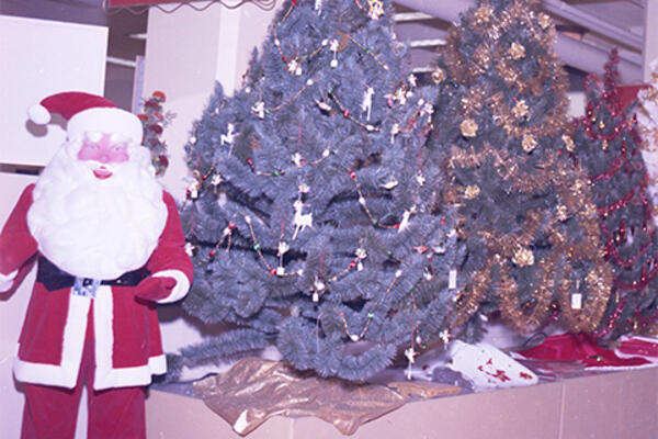 Santa Claus character posed with Christmas Tree