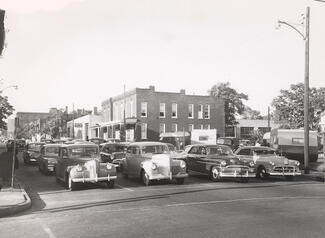 Black and white photo of automobiles waiting at a stoplight