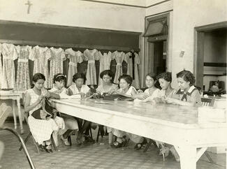 Group of women at a table sewing