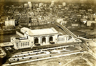 Aerial city view showing a train station in the foreground