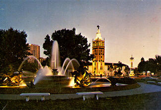 Color photo of an illuminated building with a tower